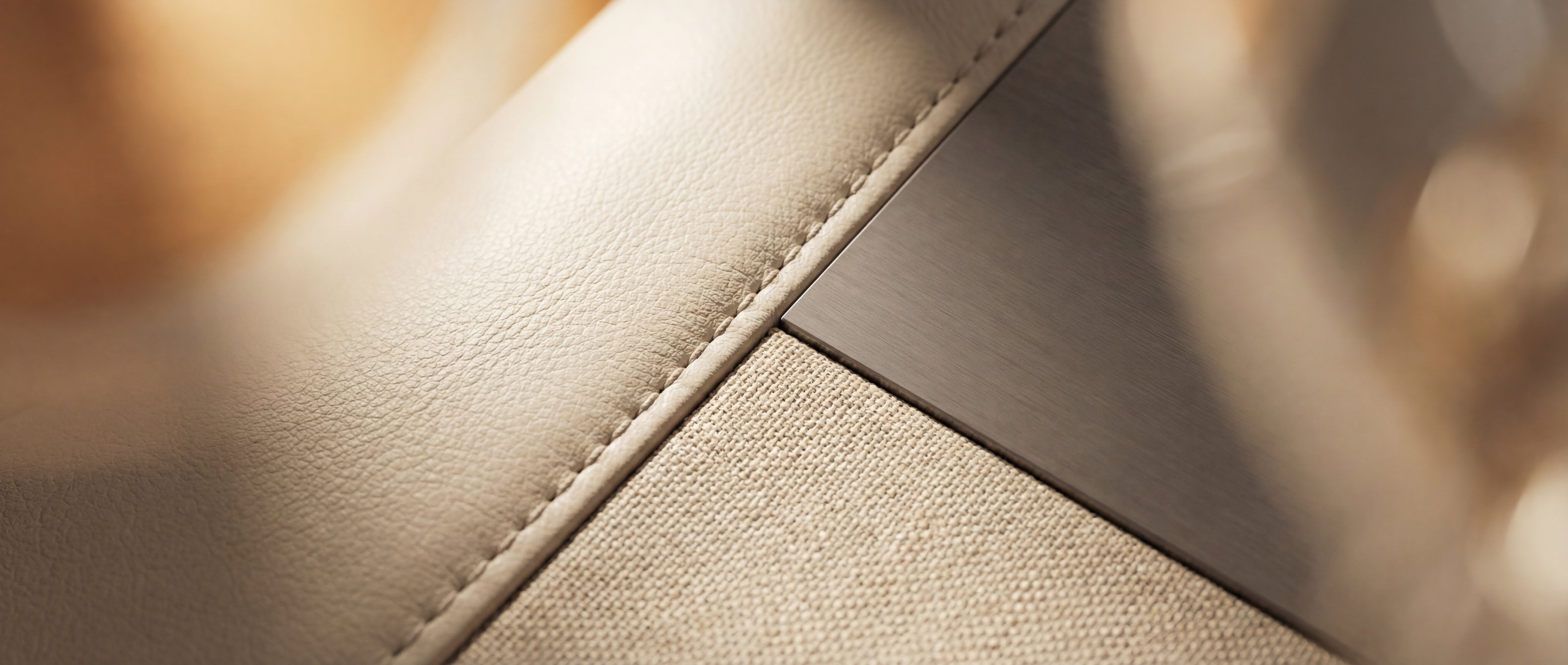Macro of a cabin material junction, full-grain leather meeting woven textile and metal